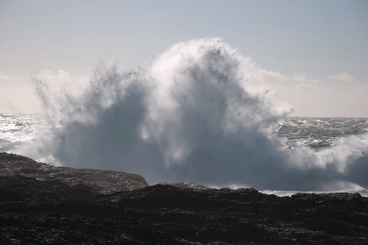 A huge winter wave exploding against Frank Island at Chesterman Beach
