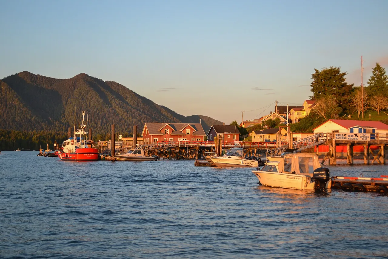 Boats and waterfront buildings in Tofino at sunset