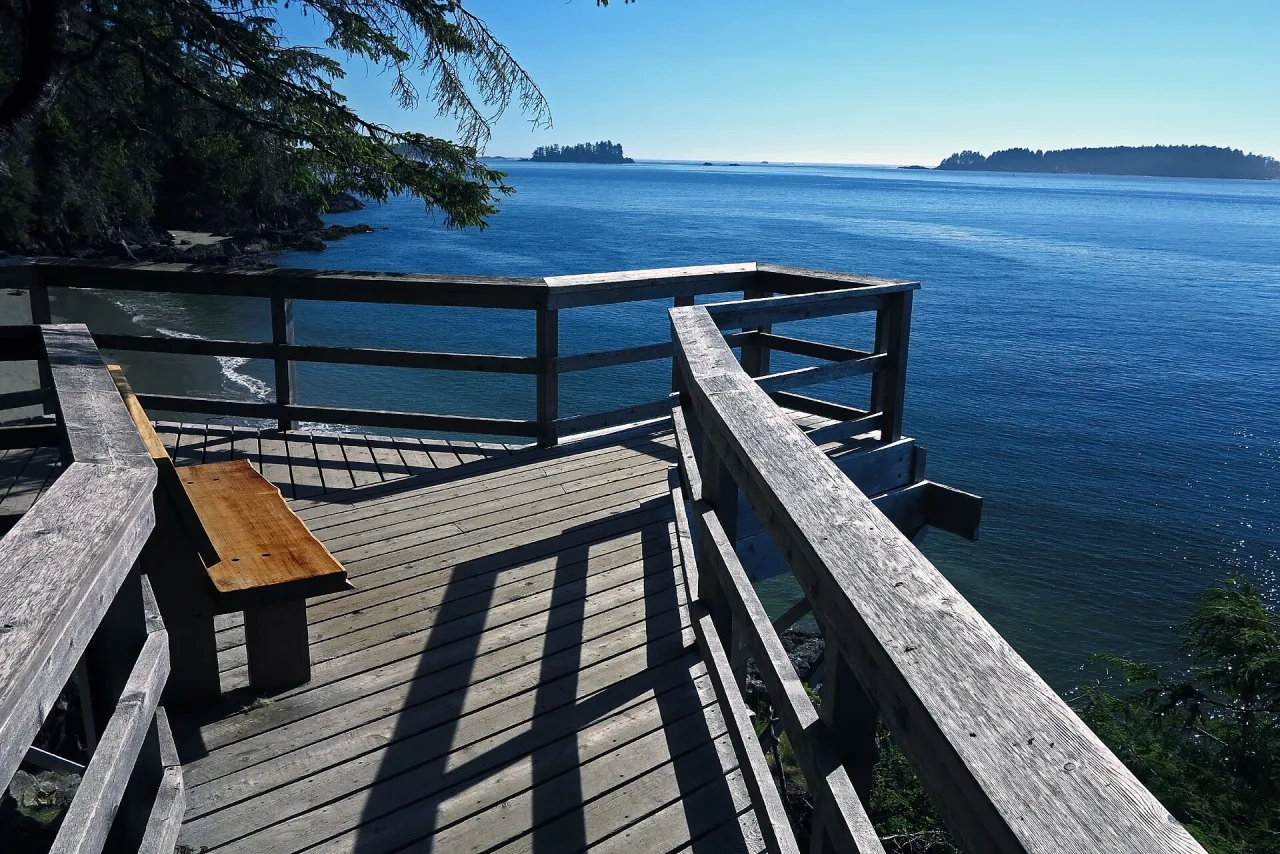 A wooden boardwalk overlook with a bench above Clayoquot Sound on the Tonquin Trail